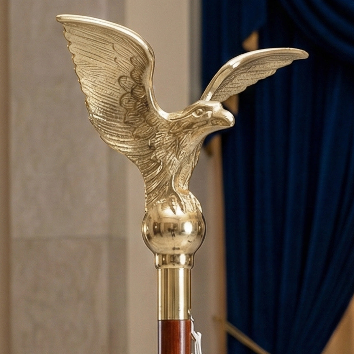 Gold eagle-shaped cane handle against a neutral background