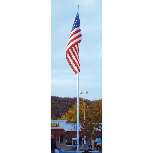 American flag on a flagpole with a building and trees in the background