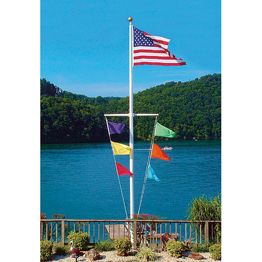 Nautical Single Mast Series flagpole with a yardarm flying an American flag and six colorful signal flags by a lake.