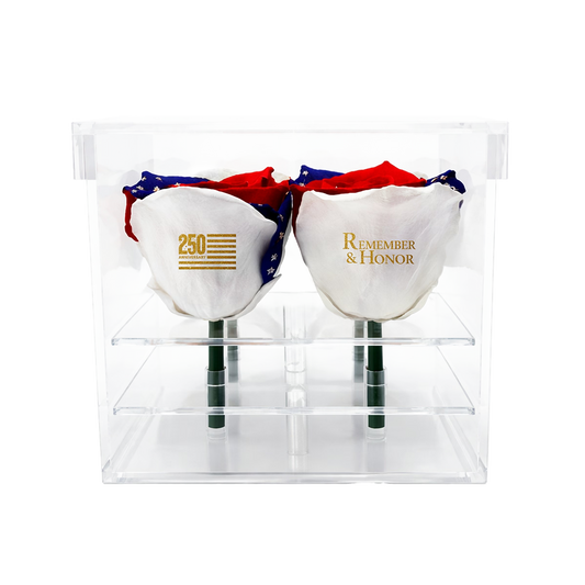 Two preserved roses with '250' and 'Remember & Honor' text, colored in red, white, and blue, and in a clear packaging.
