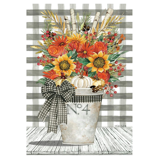 Decorative fall-themed garden banner with an arrangement with flowers, pumpkins, and a checkered bow in a metal bucket on a striped background.