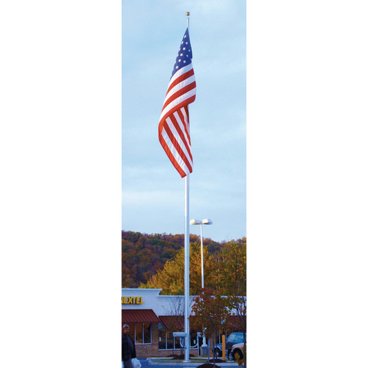 American flag on a flagpole with a building and trees in the background