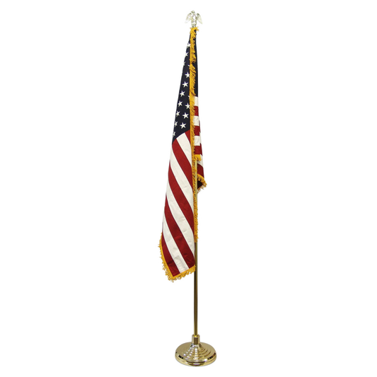 Indoor American flag with gold fringe on a gold pole with an eagle finial and base.