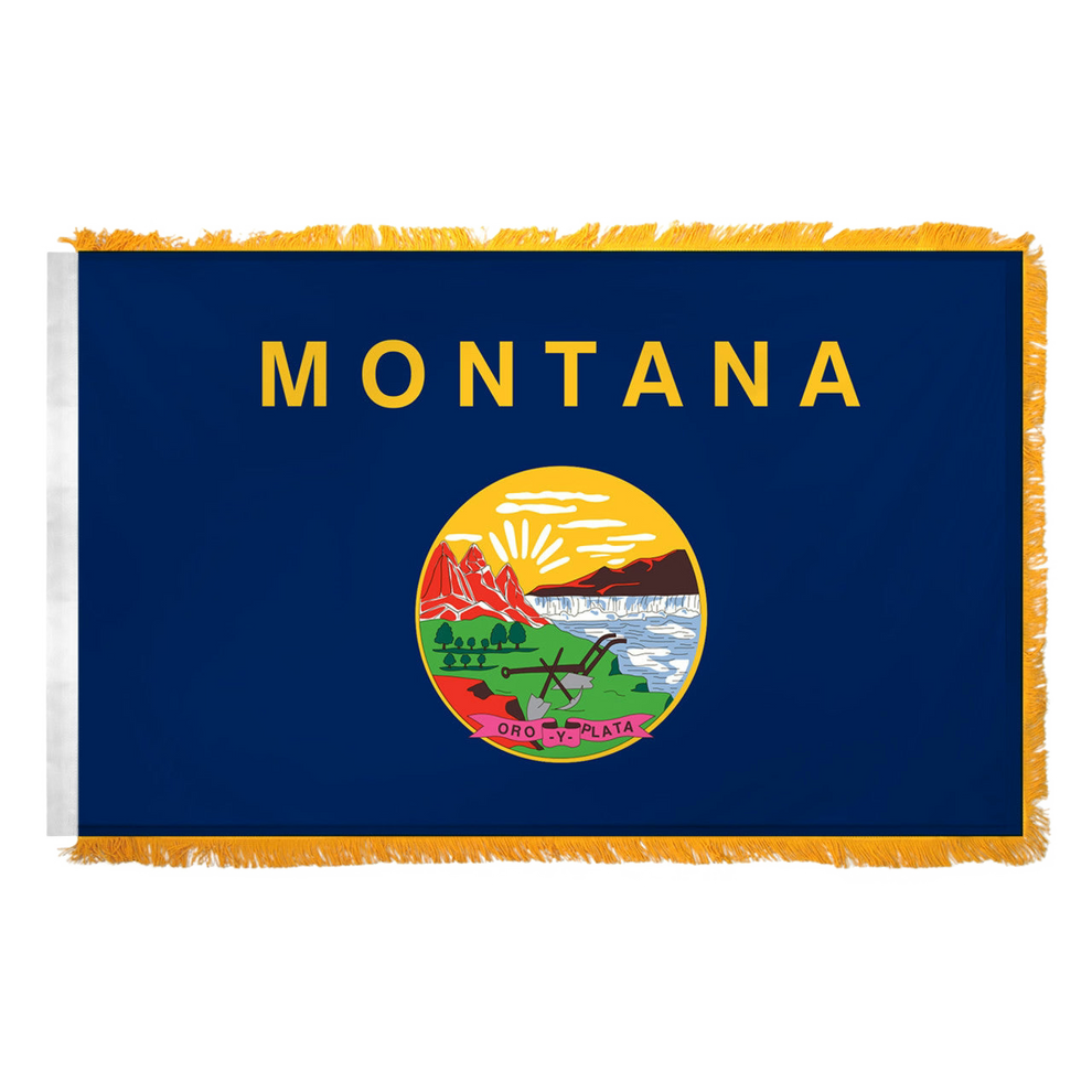 State of Montana flag with 'MONTANA' printed in large, gold all-caps letters across the top. Centered below the text is the full-color state seal, depicting a landscape with the Rocky Mountains, the Great Falls of the Missouri River, a plow, a shovel, and a pick. A ribbon at the bottom of the seal reads the Spanish motto 'ORO Y PLATA'. Flag features yellow fringe.