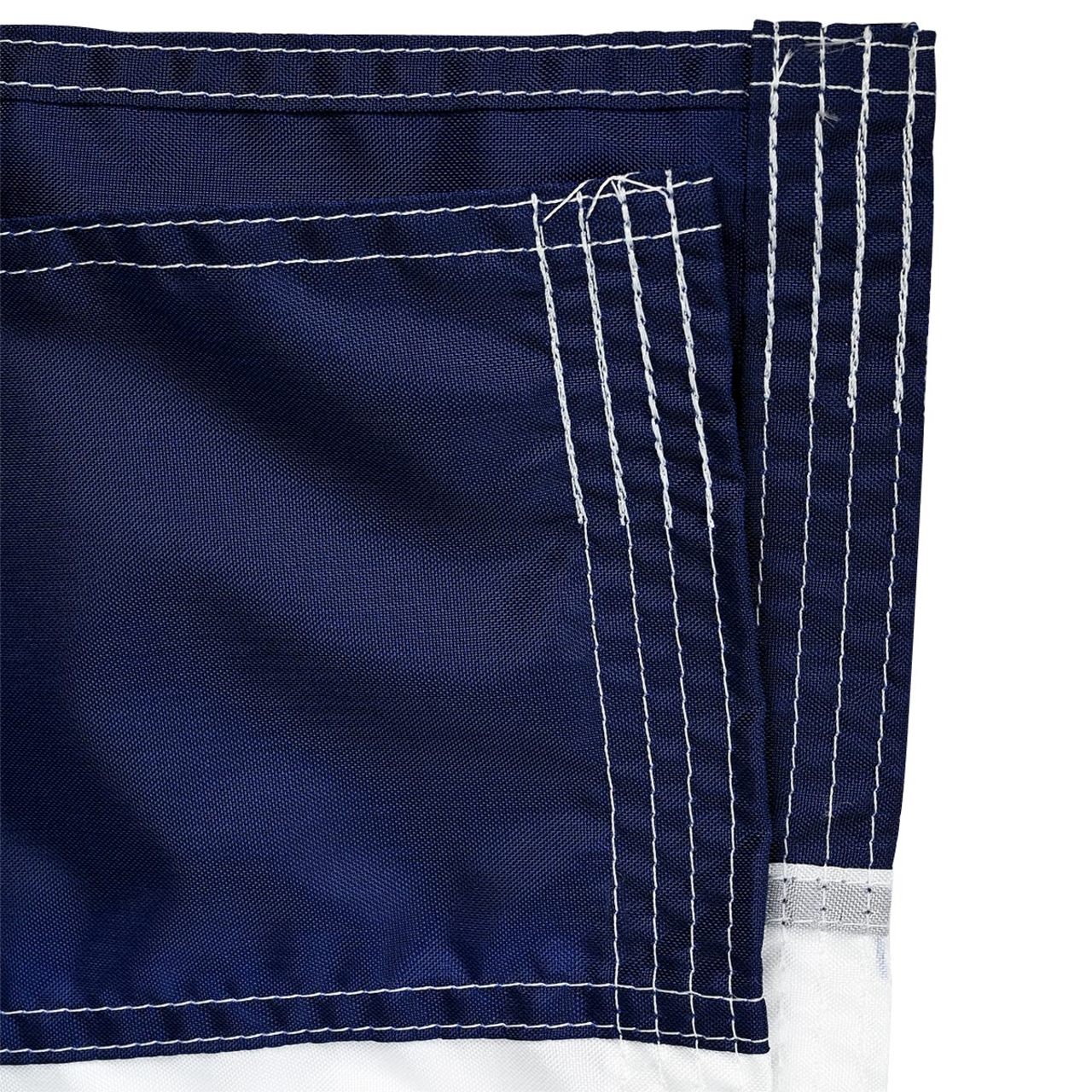 Close up of blue fabric from a flag with white stitching