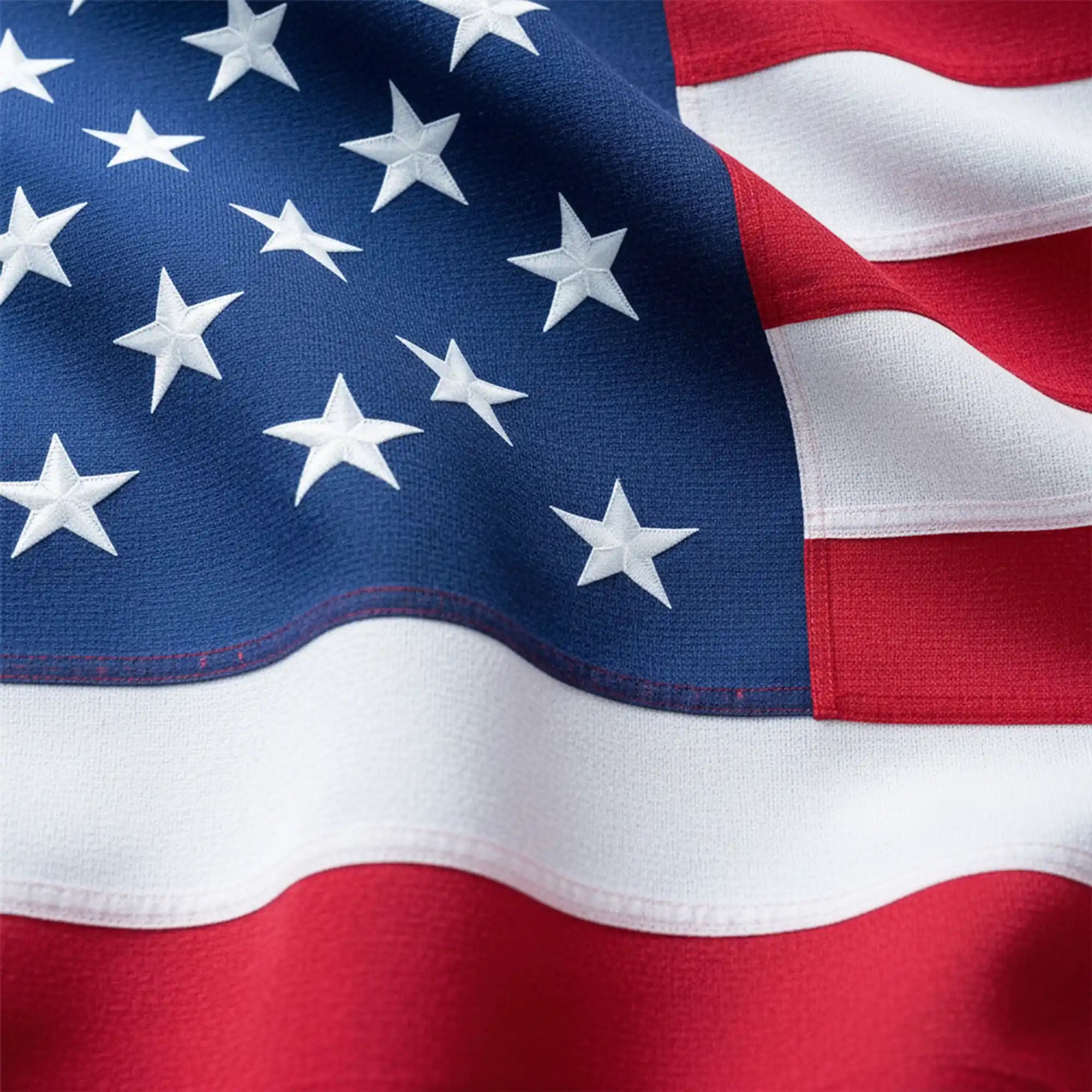 Detailed close-up of spun polyester American flag fabric showing heavy-duty weave and vibrant red, white, and blue colors.