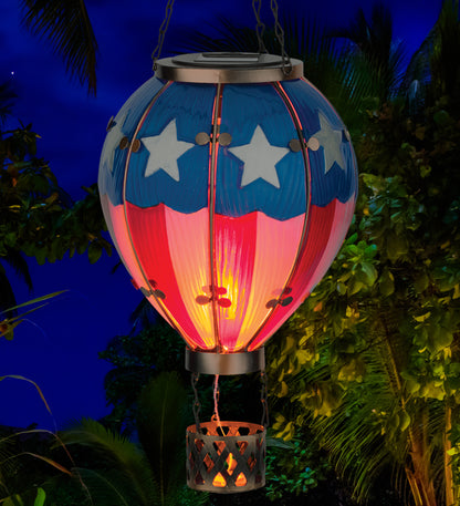 Solar-powered hot air balloon lantern with American flag design, glowing in the dark.