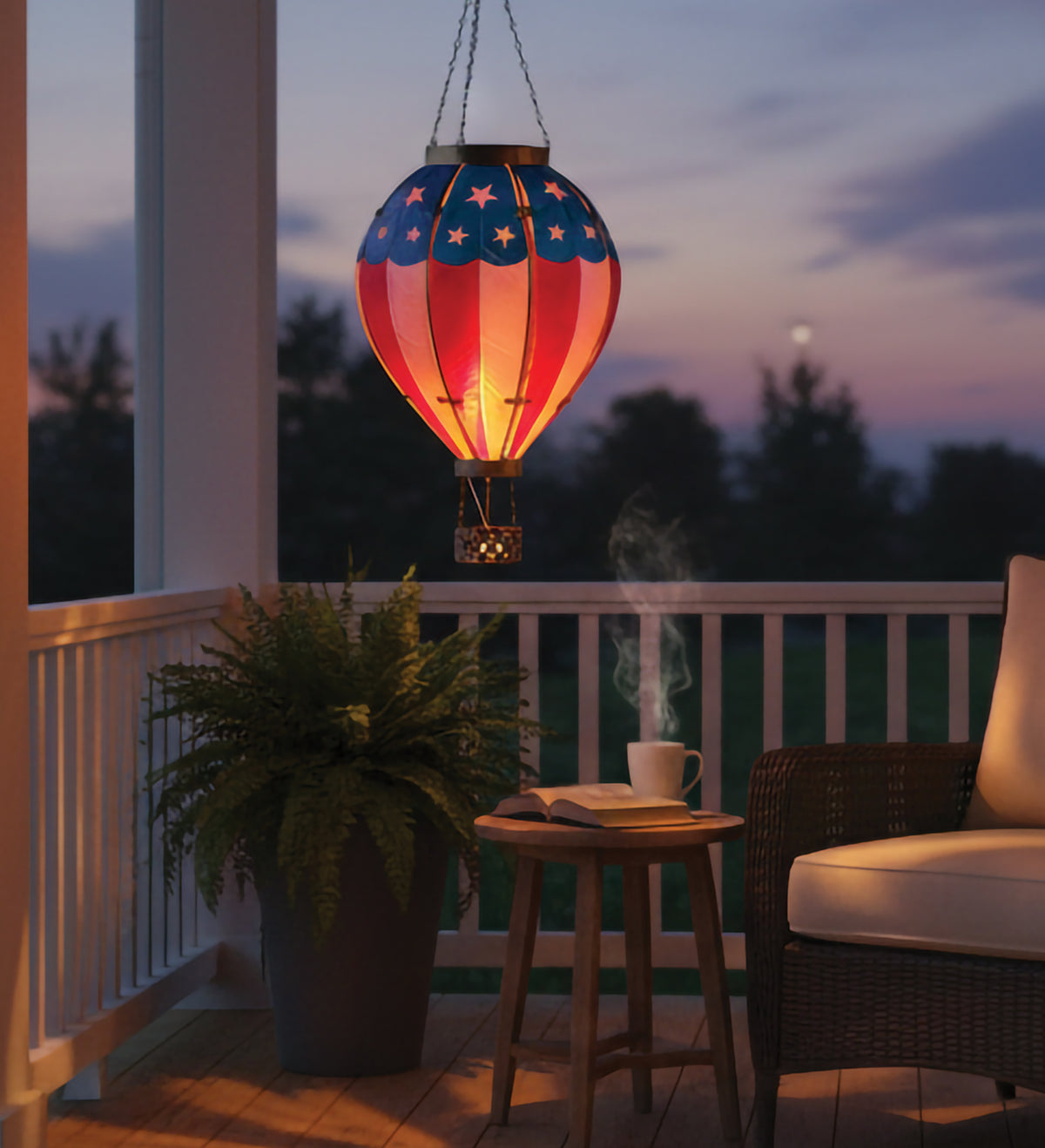 Hanging lantern with American flag design on a porch at dusk