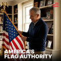 A man adjusting a high-quality indoor American flag with gold fringe in a classic home library; captioned "America's Flag Authority.
