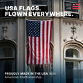 5ft x 8ft US flag hanging vertically from a grand stone building, showcasing American craftsmanship.