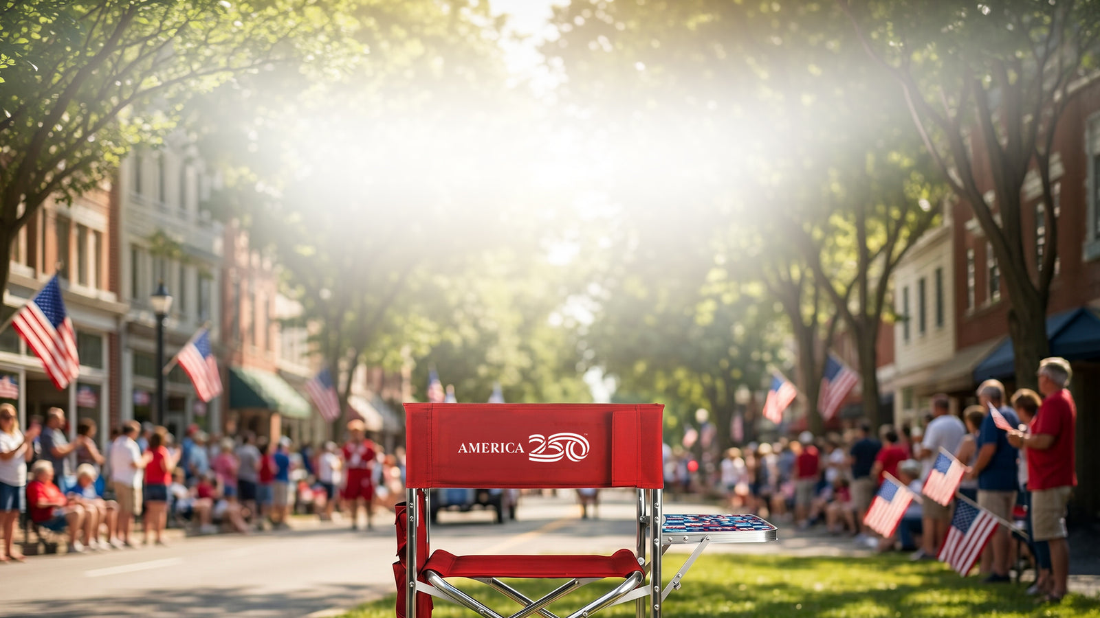 Red chair with 'America 250' sign in a town square with people and American flags.