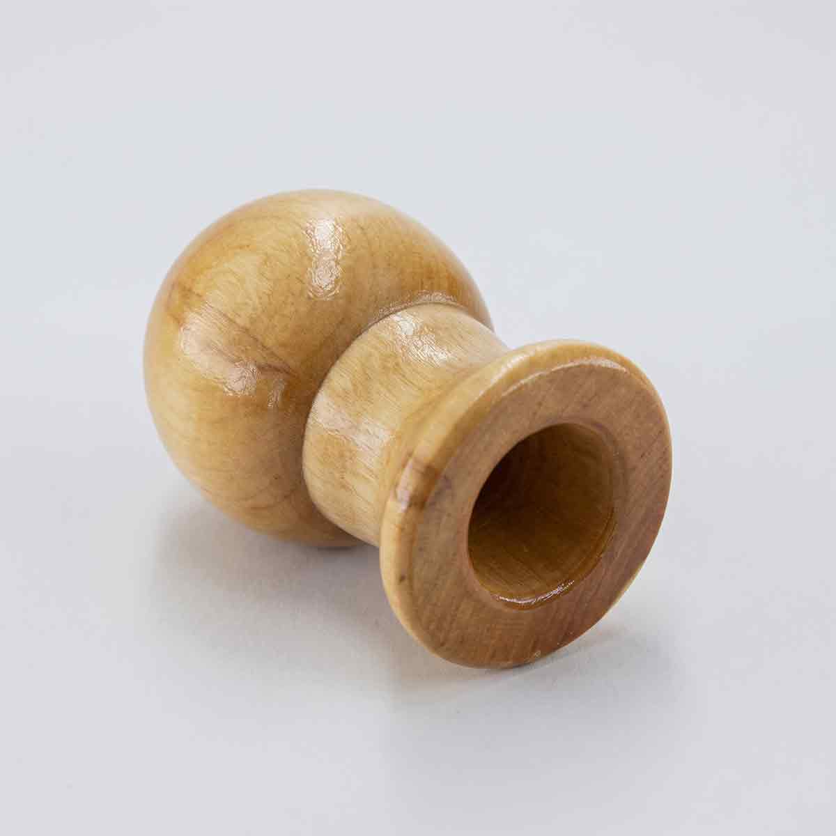 Bottom view of a wooden flagpole ball topper showing the mounting hole.