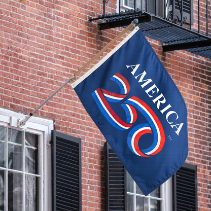 Flag with 'America 250' design on a flagpole attached to a brick building