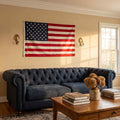 American flag hung on living room wall above a navy blue sofa