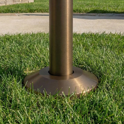 Bronze-colored metal post base on grass