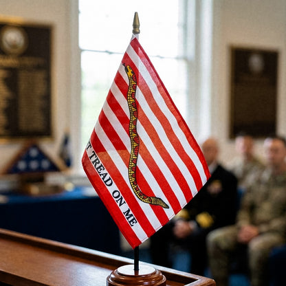 American First Navy Jack Don't Tread on Me flag with a snake design on a wooden stand, blurred background of people and flags.