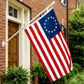 American flag with 13 stars on a pole in front of a brick building