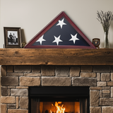 Framed American flag on a stone fireplace mantel with decorative items.