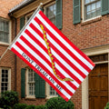 Flag with 'Don't Tread on Me' design in front of a brick building