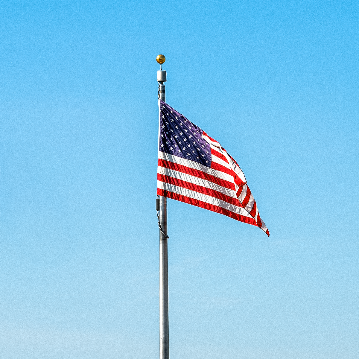 American flag on a pole against a clear blue sky