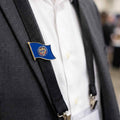 state flag lapel pin on a suit jacket with suspenders