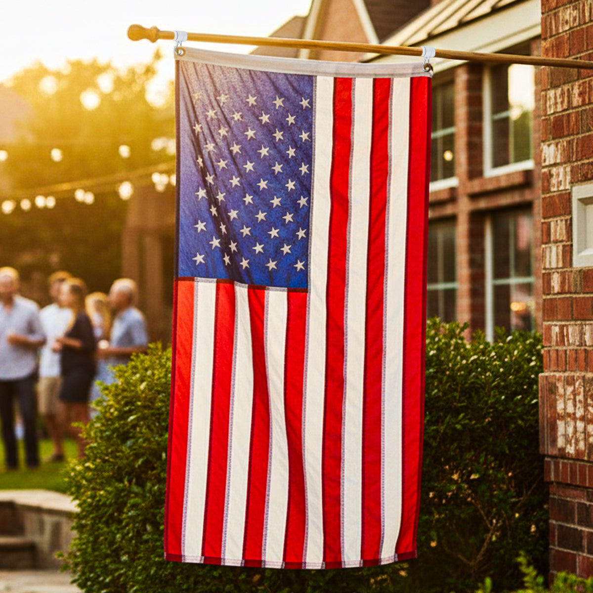 American flag hanging outdoors with people and a building in the background