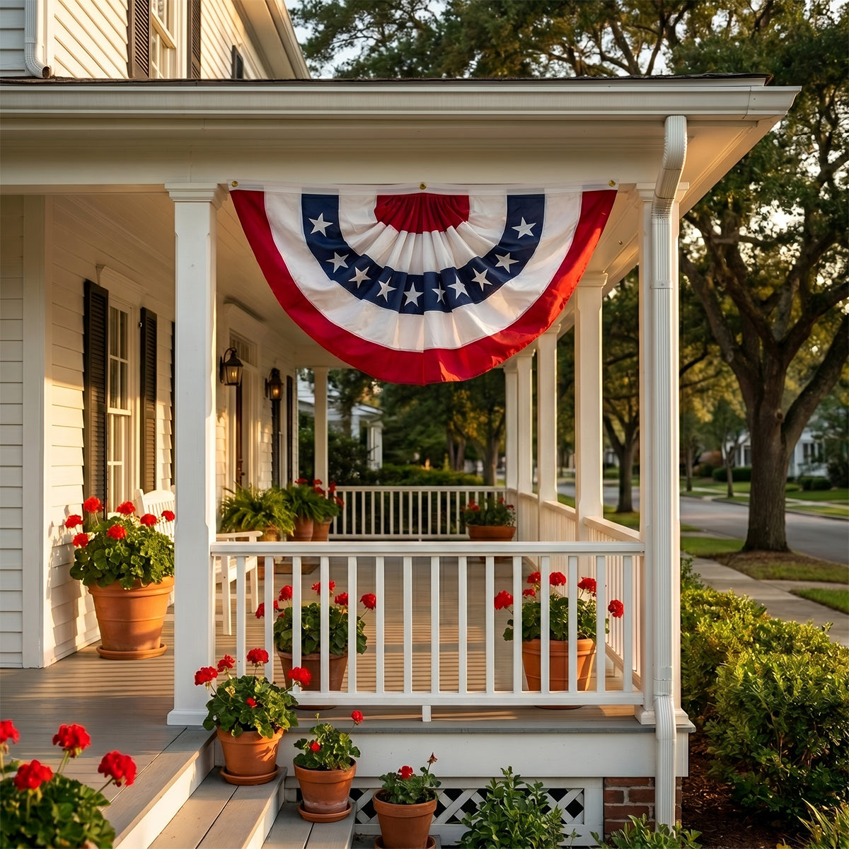 Front porch with a large American flag banner and potted plants on a sunny day.