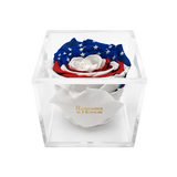 Rose arrangement with American flag design in a clear box, featuring the text 'Remember & Honor'.