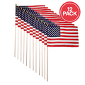Twelve small American flags on wooden sticks arranged in a fan shape, with a red circular badge in the top right that reads '12 PACK' on a white background.