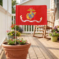 United States Marine Corps flag displayed on a garden flagpole in a flower pot on a residential porch
