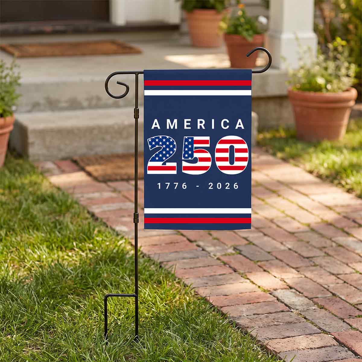 America 250 garden flag next to a brick walkway.