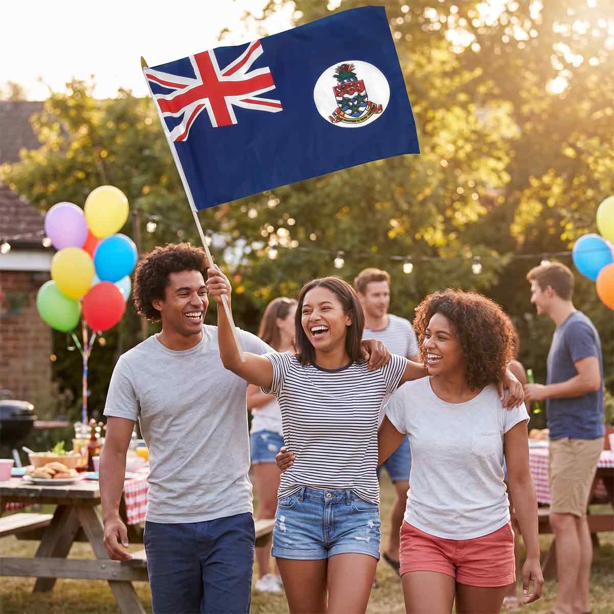 Cayman Islands flag held at an outdoor backyard party with friends