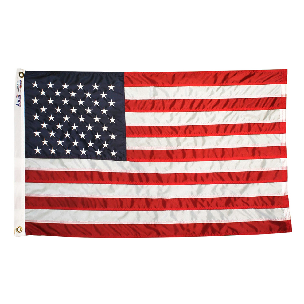 An American flag with red and white stripes and a navy blue canton with white stars, shown flat against a plain white background. The left edge has a white header with metal grommets.