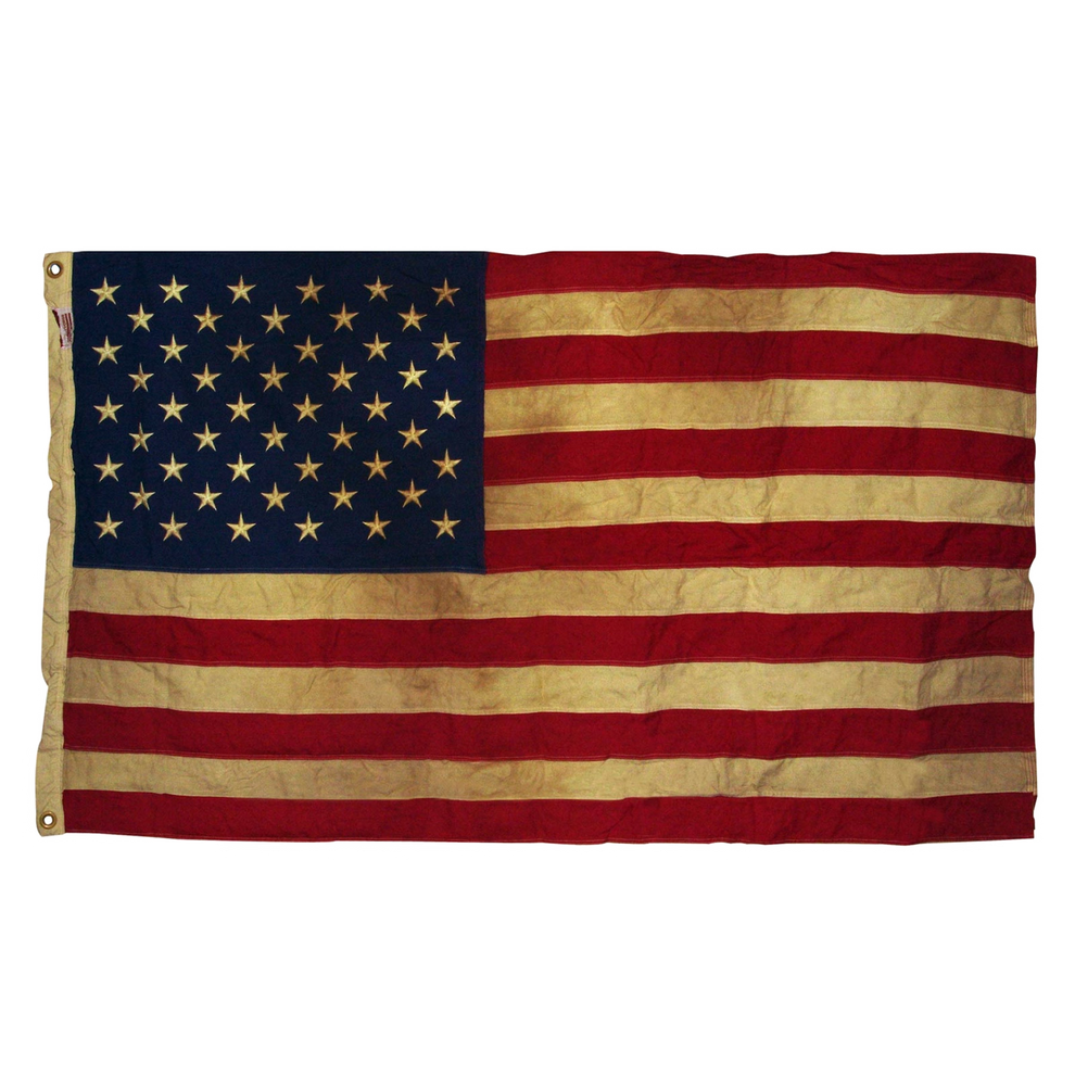 Vintage American flag with visible wear on a white background