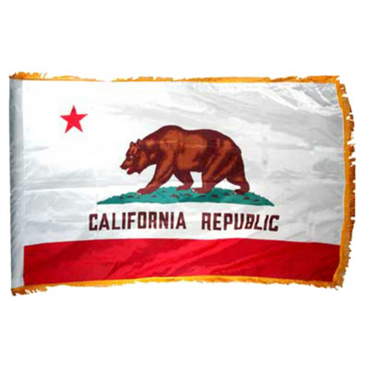 State of California flag featuring a grizzly bear, a red star, and the words 'CALIFORNIA REPUBLIC' on a white background with a red bottom stripe.  Flag has yellow fringe.