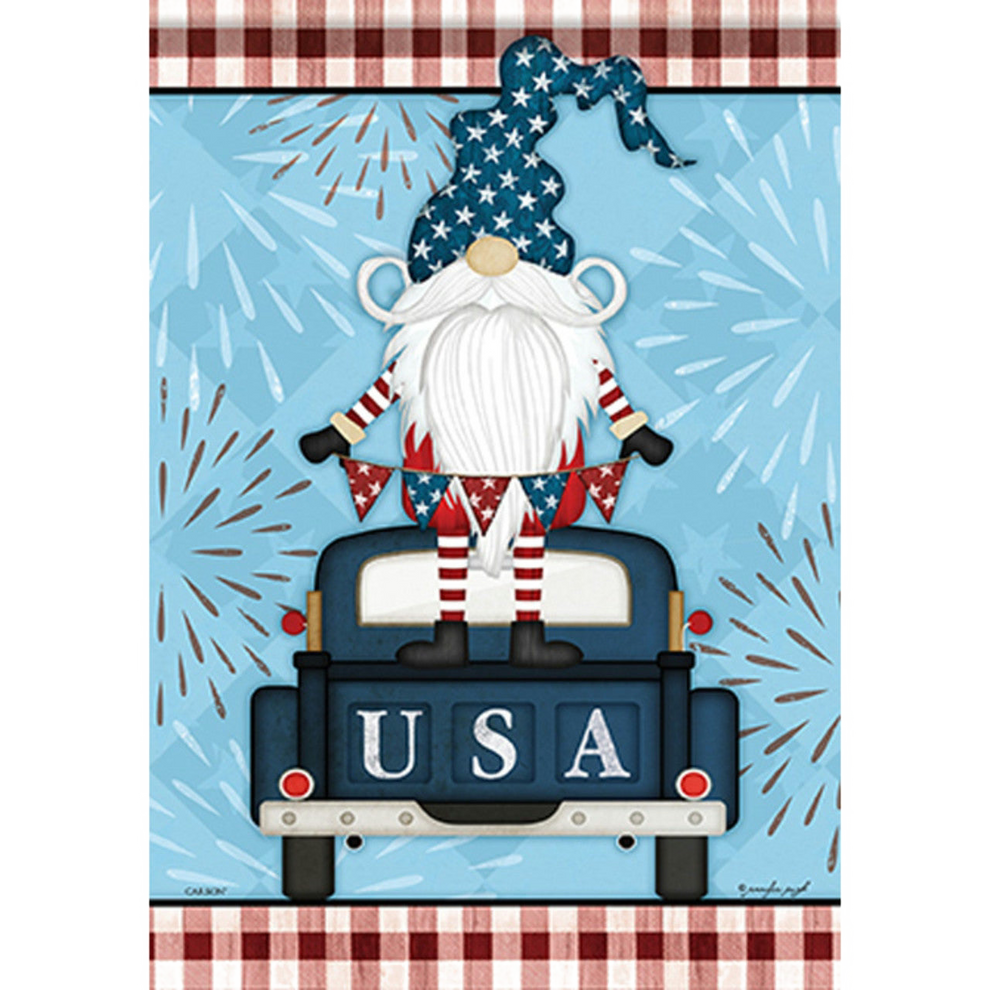 Decorative flag with a Gnome in an American flag hat sitting in a truck with 'USA' on the back, against a blue background with fireworks.