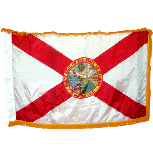 State of Florida flag featuring the classic red diagonal cross on a white background with the full-color Florida state seal in the center.  The words 'GREAT SEAL OF THE STATE OF FLORIDA' and 'IN GOD WE TRUST' are written on the edges of the seal.  This flag feature yellow fringe.