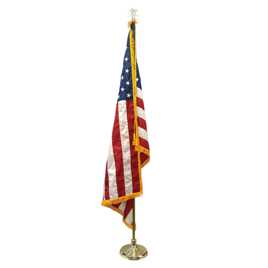Indoor American flag with gold fringe on a gold pole with an eagle finial and base.