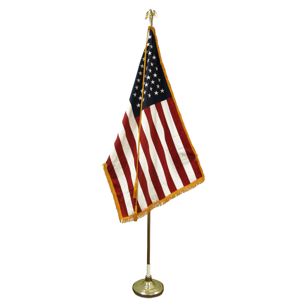American flag on a wooden flagpole with gold base and gold eagle finial
