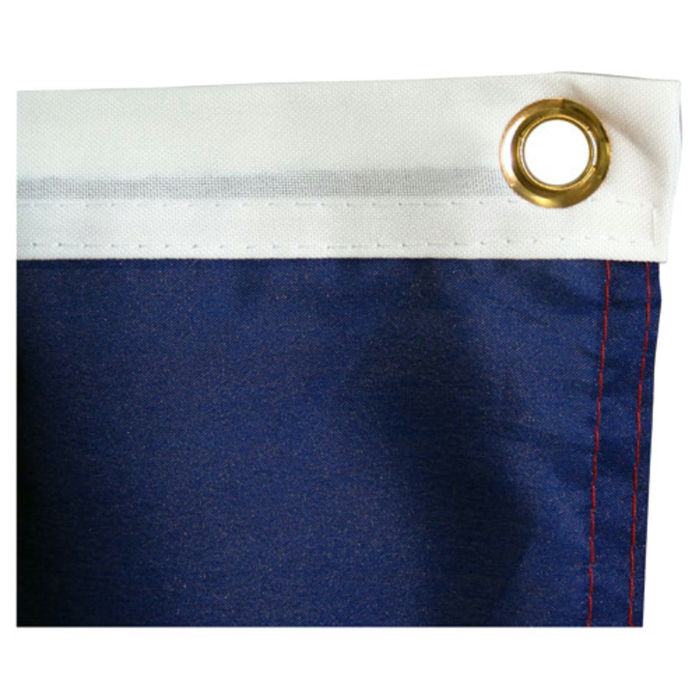 Close-up of blue flag fabric with a white header, brass grommet, and red stitching.