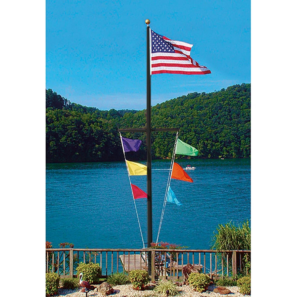 Black Nautical Single Mast Series flagpole with a yardarm flying an American flag and six colorful signal flags by a lake.