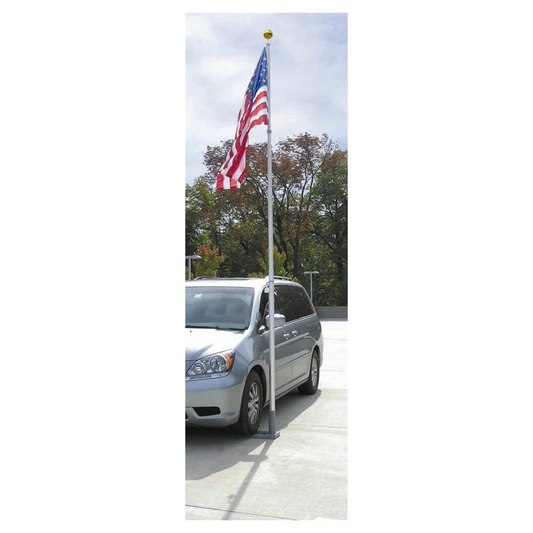 Silver minivan parked on a driveway with an American flag on a pole.