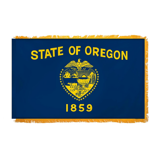 Flag of the State of Oregon with yellow text and emblem on a blue background.  Flag has fringe on its edges.