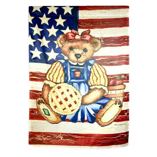 Decorative flag with a bear in overalls holding a pie with an American flag background