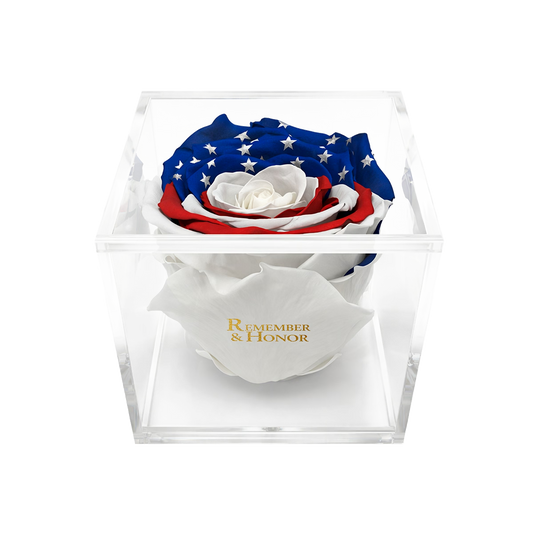 Rose arrangement with American flag design in a clear box, featuring the text 'Remember & Honor'.