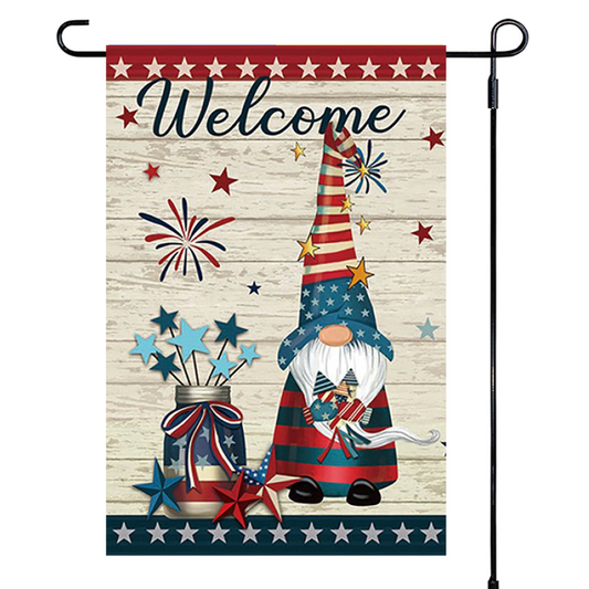 Decorative garden flag with a gnome, stars, and fireworks design on a wooden background.