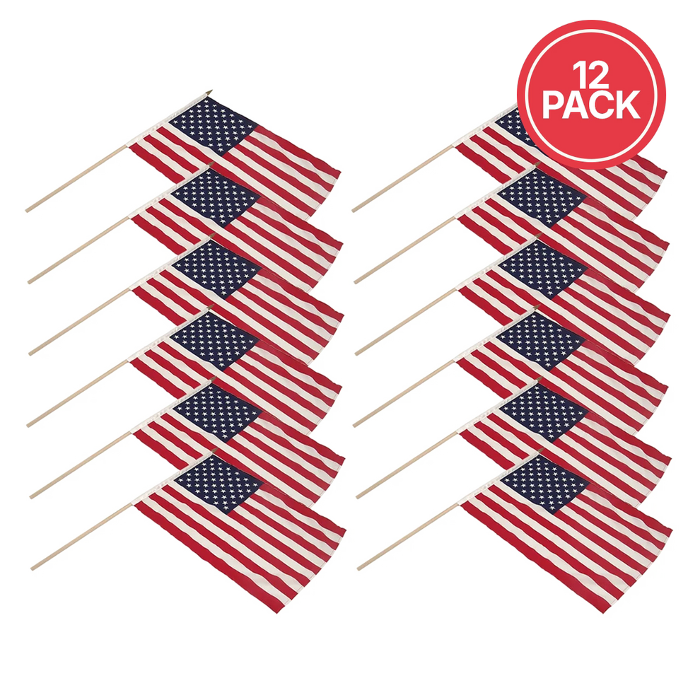 Twelve small American flags on wooden sticks, arranged in two rows of six on a white background, with a red circular badge in the top right that reads '12 PACK'.