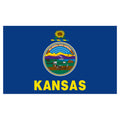 State of Kansas blue flag with Kansas state seal in the center, depicting a landscape with a rising sun, a steamship, a settler plowing a field, a covered wagon train, and Native Americans hunting buffalo. Above the scenery is the Latin motto 'AD ASTRA PER ASPERA'. Above the seal sits a gold and blue sunflower twist, and the word 'KANSAS' is printed in large, gold all-caps letters directly below the seal.
