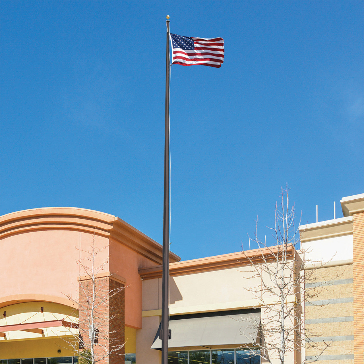 A 25ft flagpole with a stationary truck, displaying an American flag, installed in front of a building.