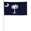South Carolina navy blue flag with white palmetto tree and moon on a wooden stick against a white background